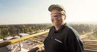 A Purina employee wearing safety goggles and a hat