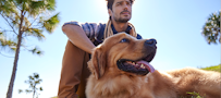 A man sitting next to a dog