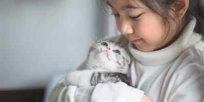 young girl holding a kitten