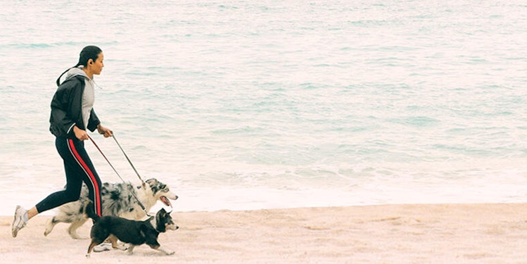 Femme qui court sur une plage propre avec son chien