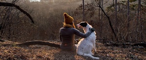 A woman sitting outdoors with her dog